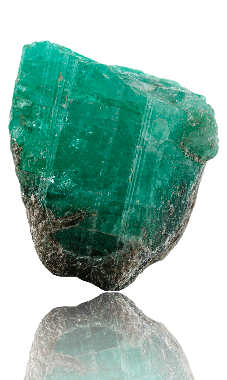 Mineral de esmeralda en su estado natural, con cristales verdes incrustados en roca, extraído de minas colombianas.