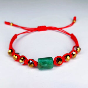 Pulsera artesanal con esmeralda cilíndrica y pedrería roja – diseño vibrante colombiano