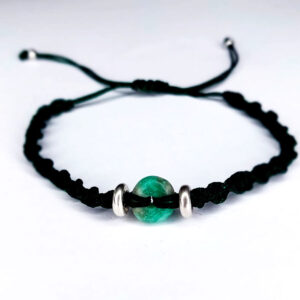 Pulsera artesanal con esmeralda cilíndrica, hilo verde y detalles en plata – joya natural colombiana